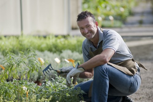 Worker wearing protective gear while trimming hedges